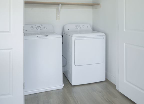 A white washing machine and dryer in a laundry room.
