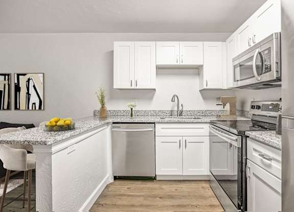 Addison Lane Apartment homes in Gainesville Florida photo of a kitchen with white cabinets and stainless steel appliances