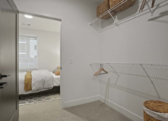 the closet in a bedroom with a bed and a mirror