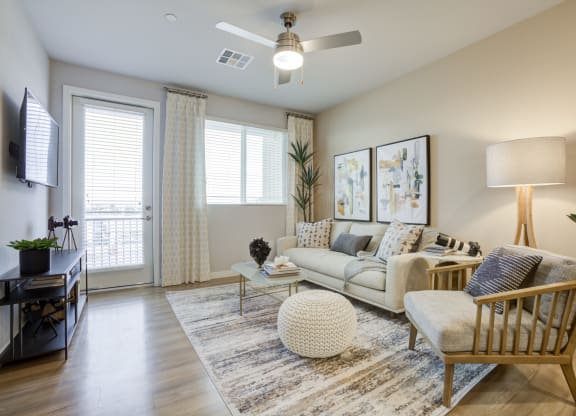 South Scottsdale Apartments - Lucent Scottsdale - a living room with a ceiling fan and a door leading to a balcony