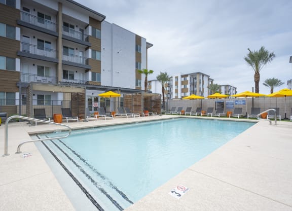 South Scottsdale, AZ Apartments - Lucent Scottsdale - Sparkling Pool With Tanning Ledge, Cabanas, Lounge Chairs, Tables, And Umbrellas