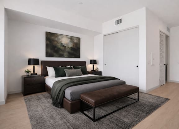 A modern bedroom with a large bed and a painting on the wall.