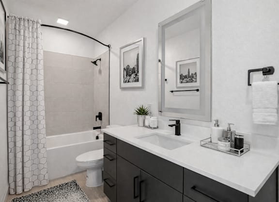 A modern bathroom with a white sink and a large mirror.