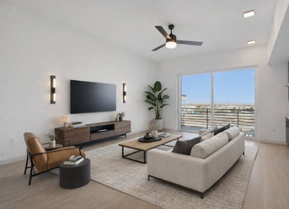 A modern living room with a flat screen TV, a sofa, a chair, and a potted plant.