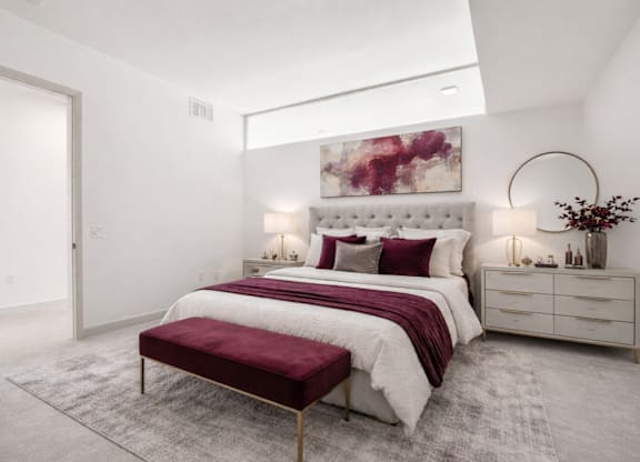 A bedroom with a large bed and a painting on the wall.