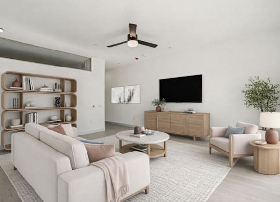 A living room with a white couch, a wooden coffee table, and a TV on the wall.