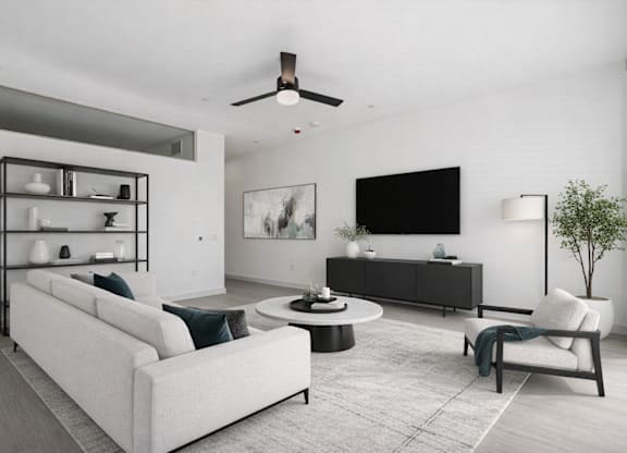A modern living room with a white sofa, a black TV, and a white chair.