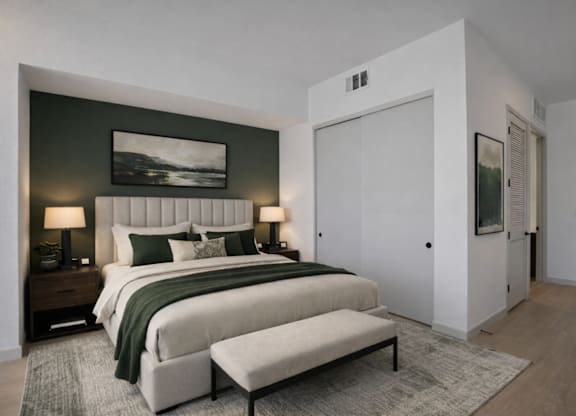 A bedroom with a large bed and a bench in front of it.