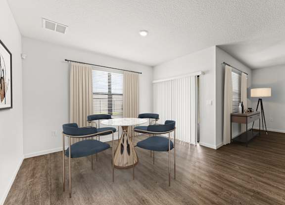 A dining room with a round table and chairs.