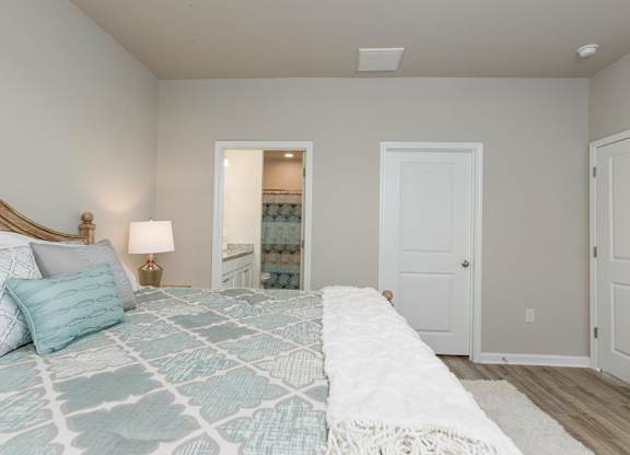 a bedroom with a bed and a door to a bathroom