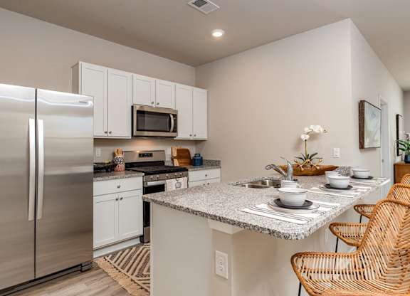 a kitchen with white cabinets and stainless steel appliances