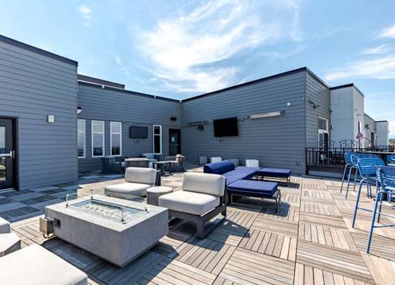 a patio with couches and chairs and a fire pit