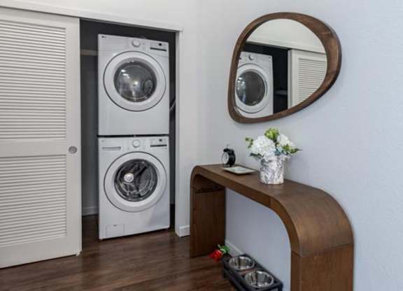 a laundry room with a washing machine and a mirror