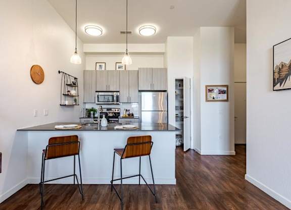 a kitchen with a bar and two stools