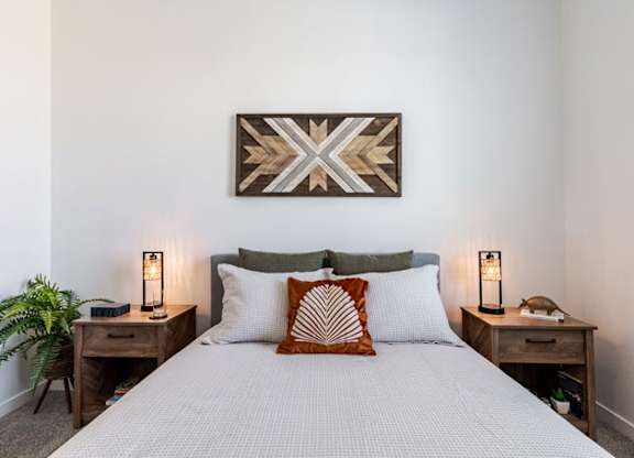 a bedroom with a bed and a painting on the wall