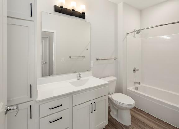 A white bathroom with a toilet, sink, and bathtub.