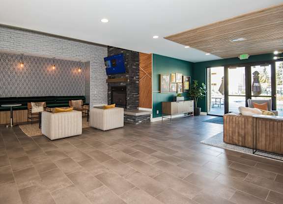 the lobby of a hotel with furniture and a fireplace