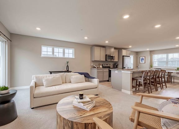 a living room and kitchen with a couch and a table