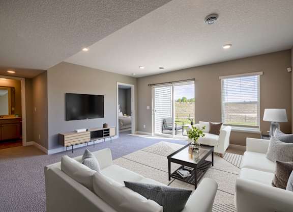 A living room with a white couch and a television.