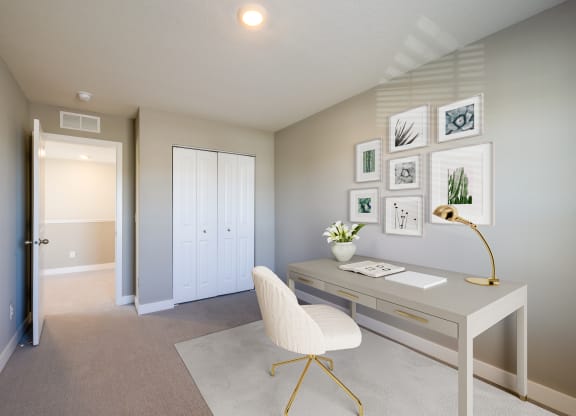 a home office with a white desk and chair and a white door
