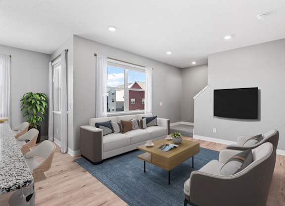 A modern living room with a sofa, chairs, and a television.