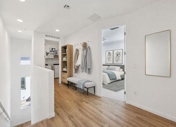 A bedroom with a bed, a bench, and a mirror.