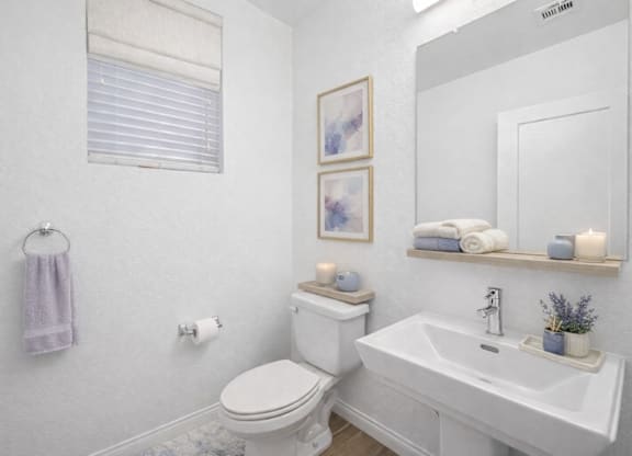 A white toilet sits next to a white sink in a bathroom.