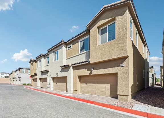 A row of houses with garages and driveways.