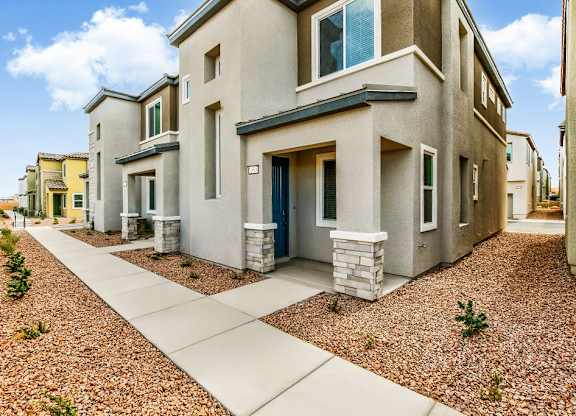 a street view of a house with a sidewalk and landscaping