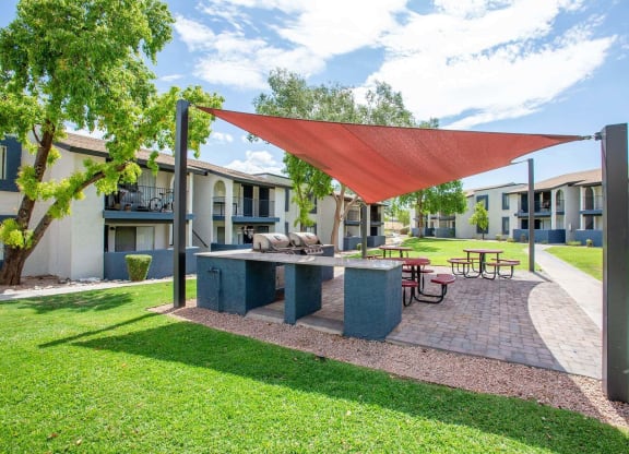 a patio with a picnic table and a red canopy