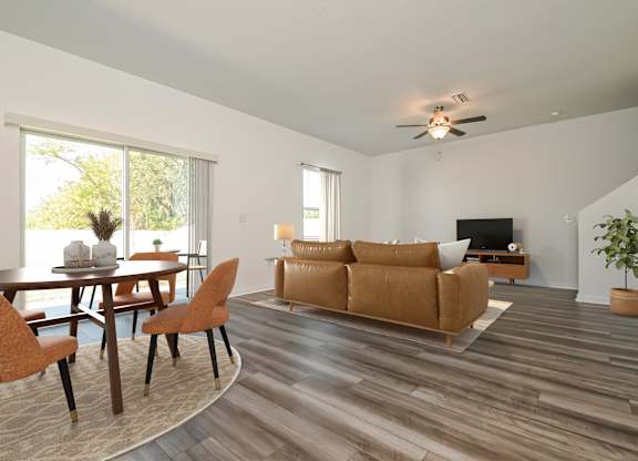 Pet Friendly Homes in Ruskin, FL - Ruskin Reserve - Living Room with wood style flooring, large windows, and ceiling fan
