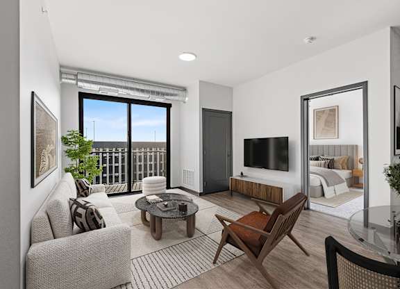 A living room with a couch, chair, and television.