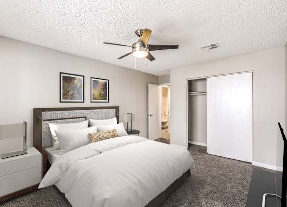 A bedroom with a large bed, a ceiling fan, and two pictures on the wall.