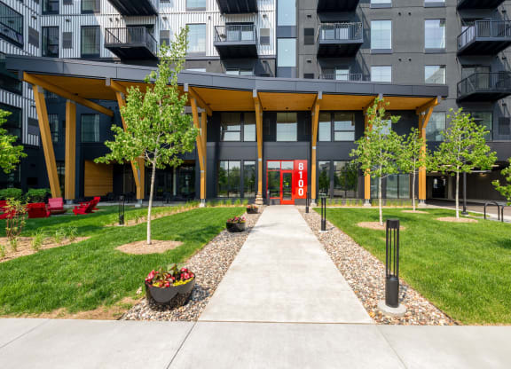 pathway leading to an apartment building with grass and trees