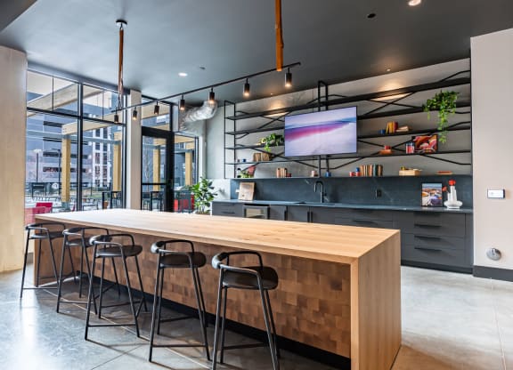 a large wooden table in a restaurant with bar stools