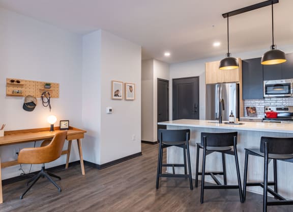a kitchen and dining area with a bar and stools