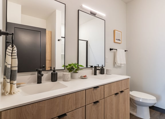 a bathroom with two mirrors and a sink and a toilet