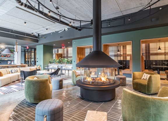 the lobby of a hotel with a large fire pit