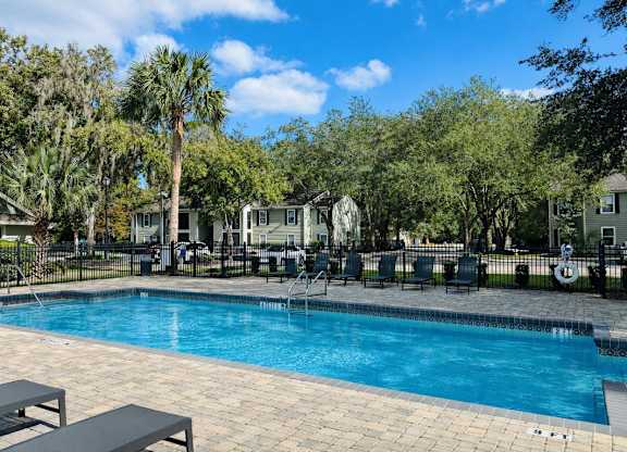 Community swimming pool with lounge seating at Chelsea Apartments in Gainesville FL