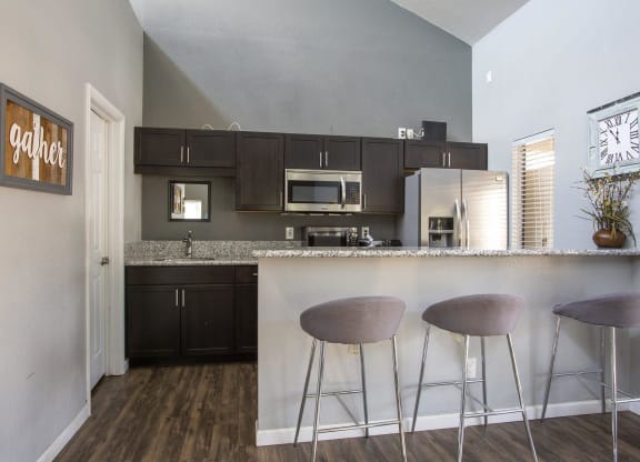 a kitchen with a bar with three stools