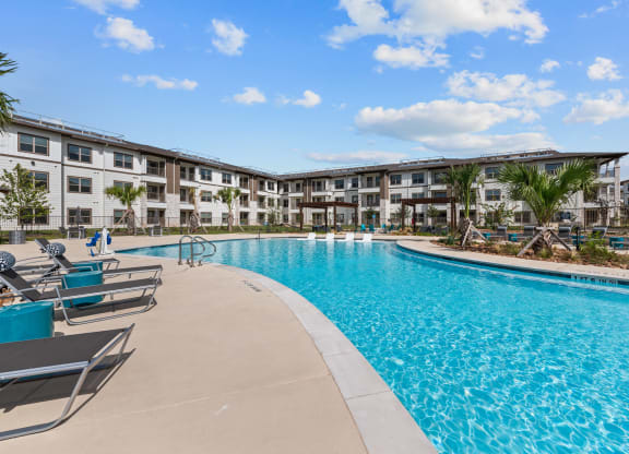 a large swimming pool with an apartment building in the background
