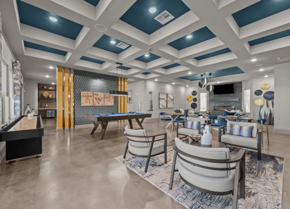 a clubhouse with tables and chairs and a pool table