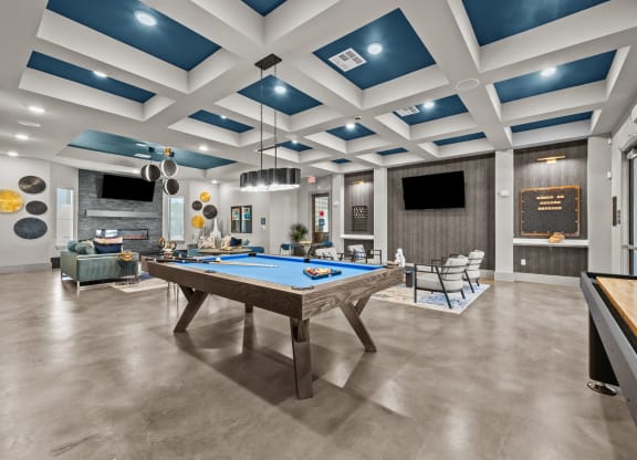 a community room with a pool table and couches