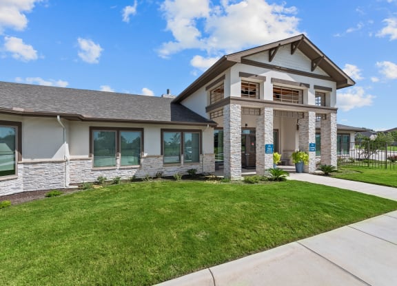 a house with a lawn and a sidewalk in front of it