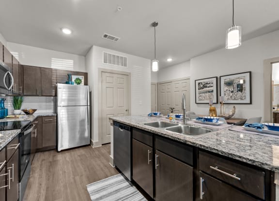 an open kitchen with stainless steel appliances and granite counter tops