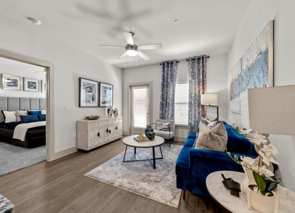 a living room with a blue couch and a ceiling fan