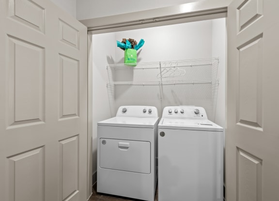 a washer and dryer in a laundry room with white appliances and white doors