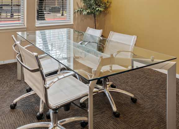 A conference room with a glass table and chairs.