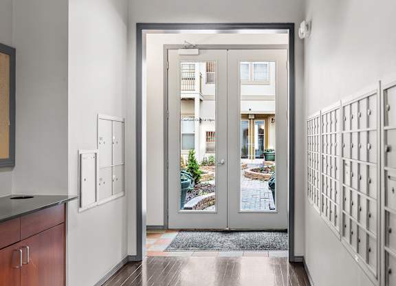 A modern interior with a view of a courtyard through a glass door.