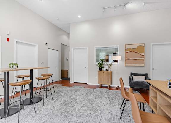 A room with a desk, chairs, and a potted plant.